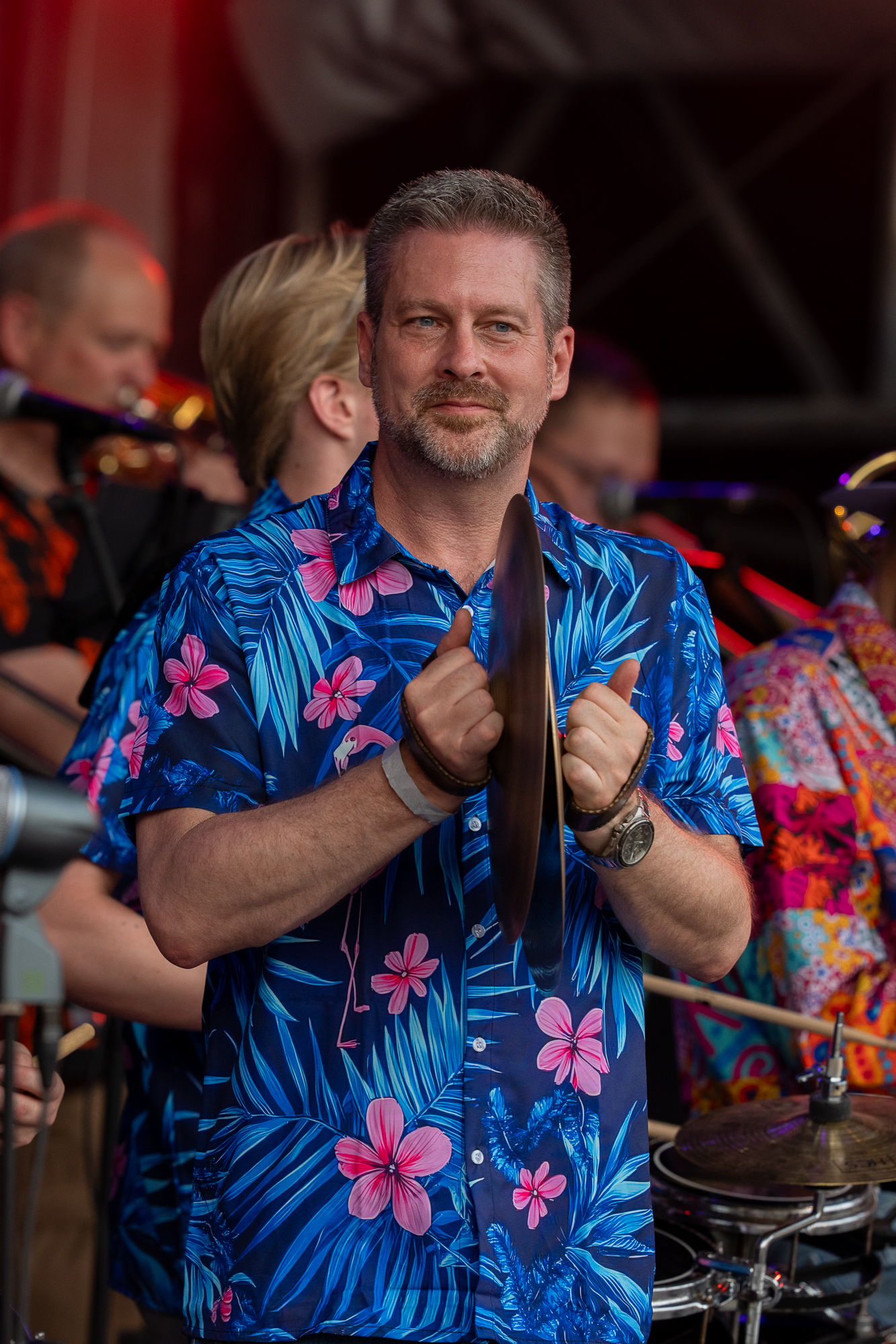 Muzikant in tropisch overhemd met drumstokken op het podium
